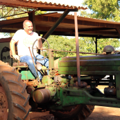 Photo: Kansas Wheat Commissioner Doug Keesling sits on an old John Deere tractor at a farm in Cuba.