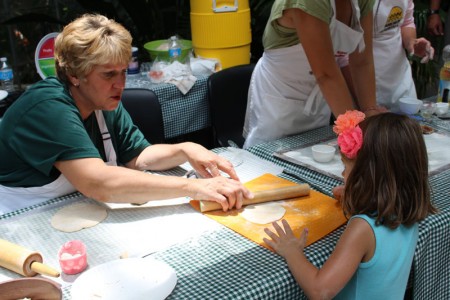 Photo: Cindy Falk demonstrates how to roll out a flour tortilla.