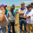 Kansas wheat farmer, Joe Kejr, explains to participants the process of harvesting wheat and how the recent rain has affected the harvest. 